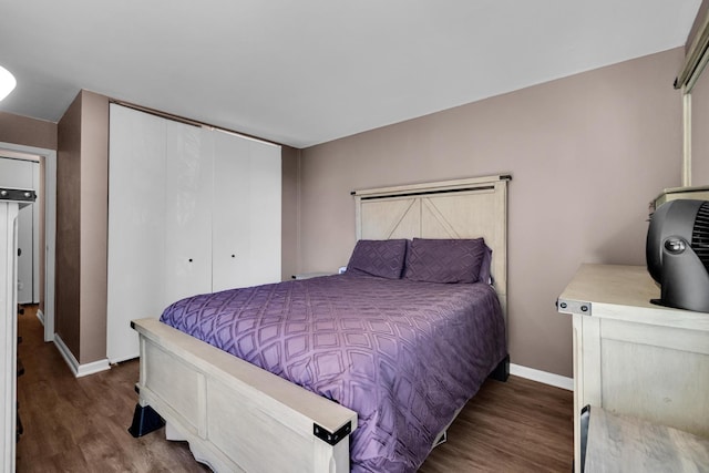 bedroom with a closet, baseboards, and wood finished floors