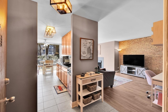 kitchen with light tile patterned floors, dishwashing machine, a ceiling fan, open floor plan, and light brown cabinetry