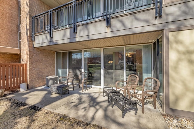 view of patio featuring cooling unit and a balcony