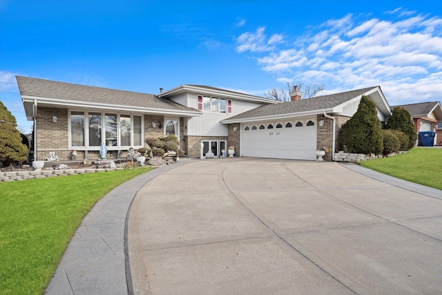 tri-level home with an attached garage, brick siding, driveway, and a front yard