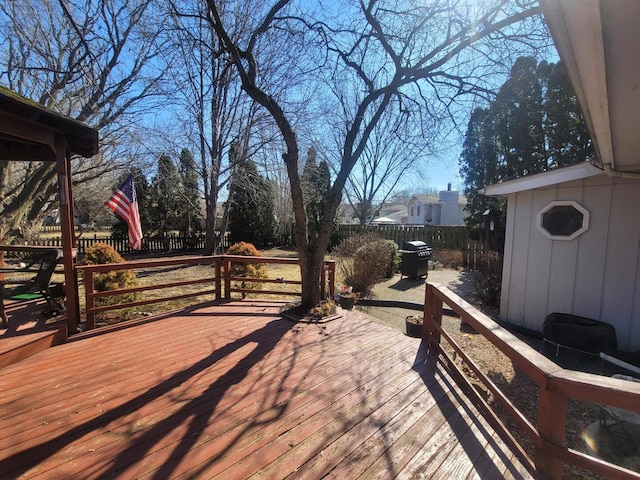 wooden terrace with a fenced backyard and a grill