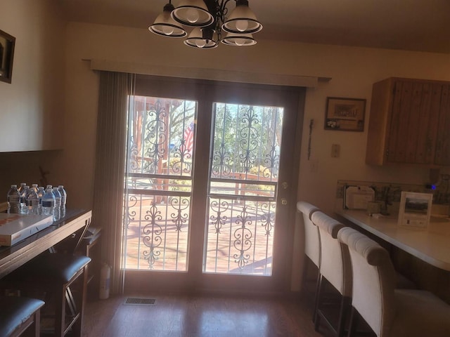 dining area featuring visible vents, a notable chandelier, and wood finished floors