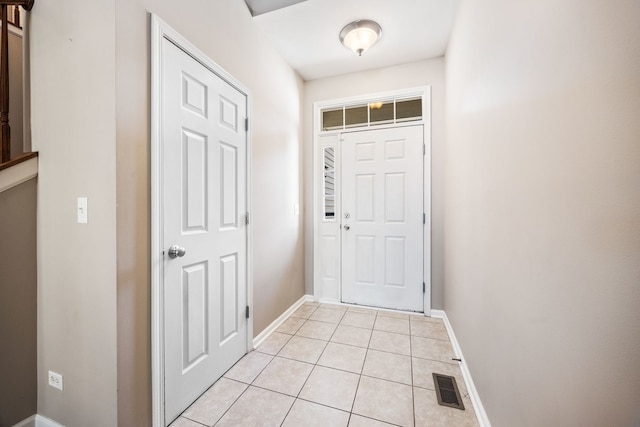 doorway featuring light tile patterned floors, baseboards, and visible vents