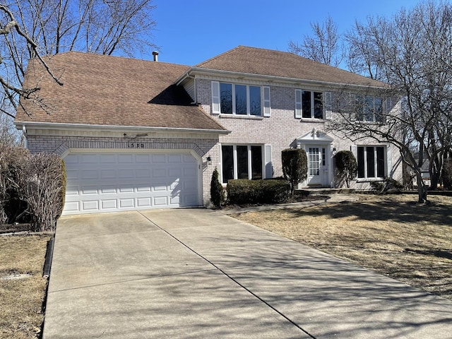 colonial home featuring an attached garage, roof with shingles, concrete driveway, and brick siding