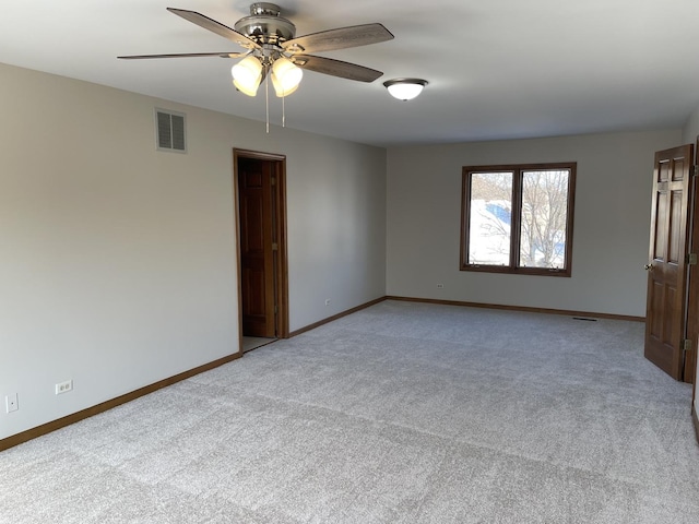 empty room with light carpet, ceiling fan, visible vents, and baseboards