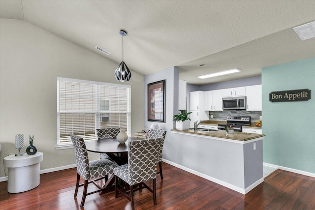 dining space with visible vents, lofted ceiling, baseboards, and dark wood-style floors