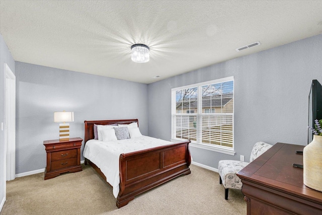 bedroom with visible vents, light carpet, a textured ceiling, and baseboards