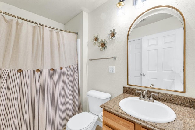 full bath featuring a shower with shower curtain, toilet, vanity, and a textured wall