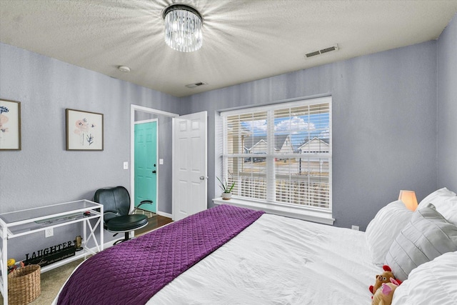 bedroom featuring an inviting chandelier, carpet flooring, visible vents, and a textured ceiling