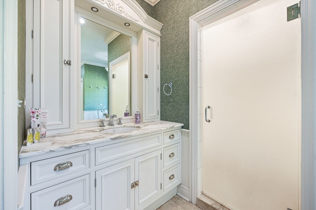 bathroom featuring crown molding, vanity, and wallpapered walls