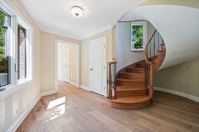 interior space featuring ornamental molding, visible vents, and wood finished floors