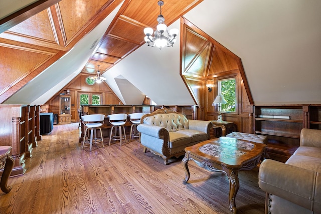 living area with lofted ceiling, wood walls, and wood finished floors