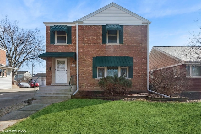 traditional-style home featuring a front yard and brick siding