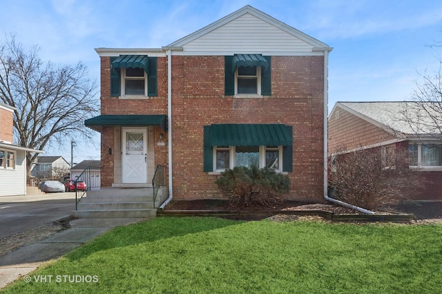 traditional home featuring a front lawn, brick siding, and driveway