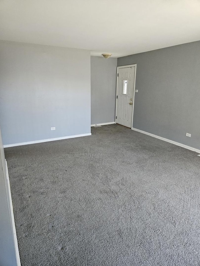 carpeted spare room featuring baseboards