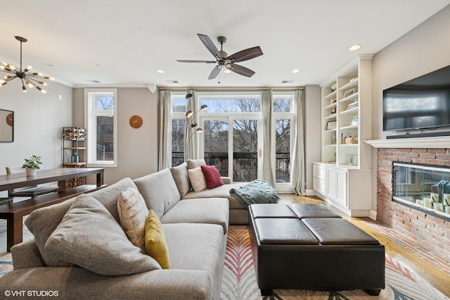 living area featuring light wood-style floors, a brick fireplace, a wealth of natural light, and built in features