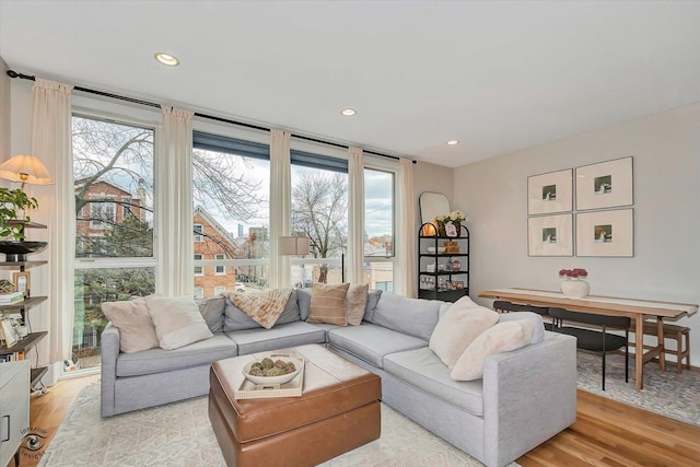 living room with a wealth of natural light, light wood finished floors, and recessed lighting