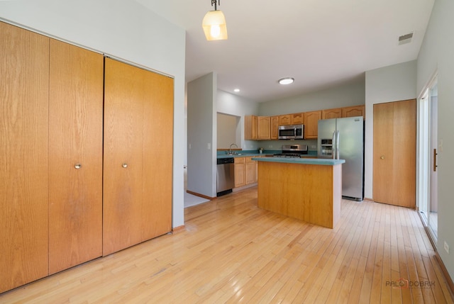 1061 Chadwick Dr, Grayslake, IL 60030 - kitchen featuring stainless steel appliances, light wood-style flooring, a kitchen island, and decorative light fixtures