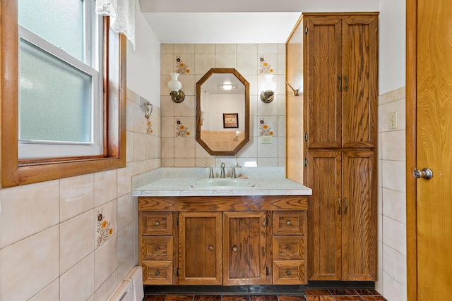 bathroom with vanity, tile walls, and a healthy amount of sunlight