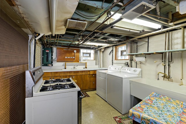 washroom with laundry area, electric panel, independent washer and dryer, light floors, and a sink