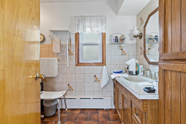 bathroom featuring baseboard heating, vanity, and tile walls