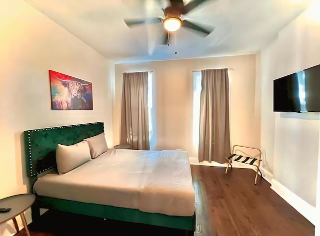 bedroom featuring ceiling fan, baseboards, and dark wood-style flooring