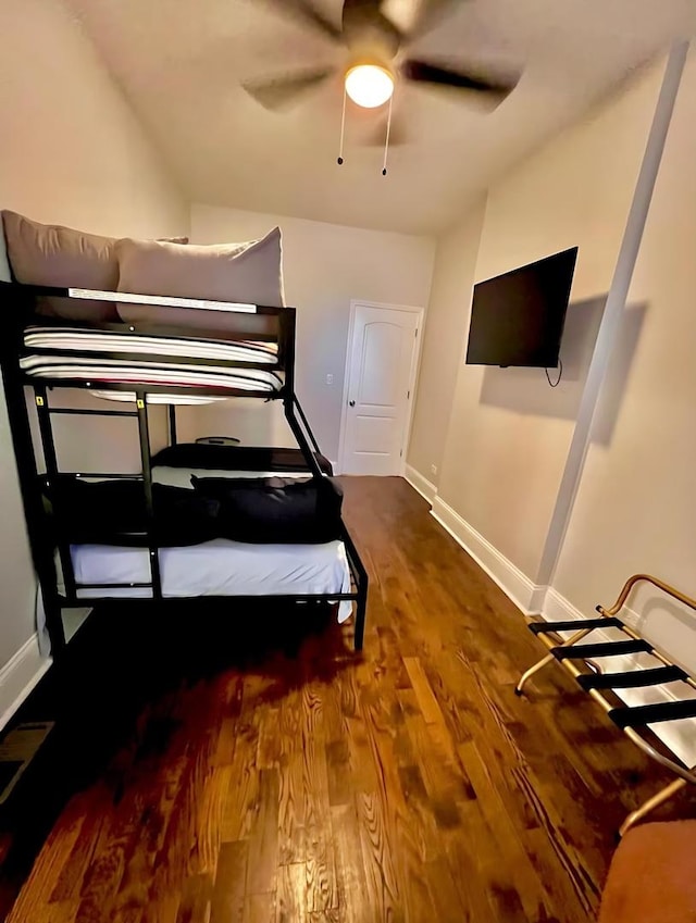 bedroom featuring a ceiling fan, baseboards, and wood finished floors