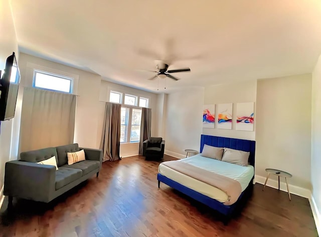 bedroom with wood finished floors, a ceiling fan, and baseboards