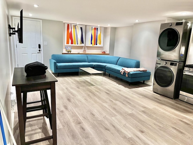 living area featuring stacked washer / dryer, recessed lighting, and wood finished floors