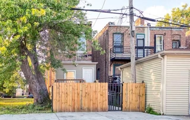 view of front facade with brick siding, fence, and a gate