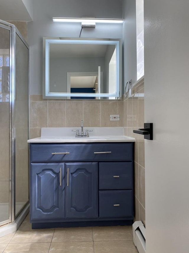 bathroom featuring a stall shower, tile patterned floors, vanity, a baseboard heating unit, and tile walls