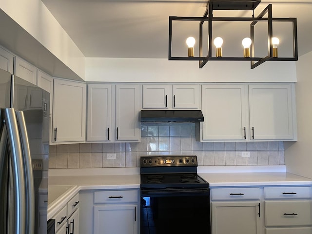 kitchen featuring black / electric stove, under cabinet range hood, light countertops, decorative backsplash, and stainless steel fridge