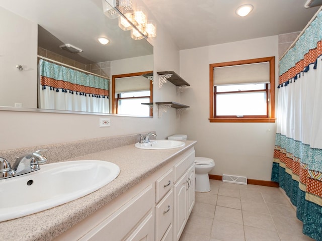 bathroom with visible vents, a healthy amount of sunlight, and a sink