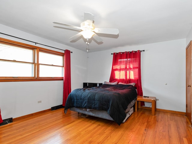 bedroom with light wood-type flooring, baseboards, and ceiling fan