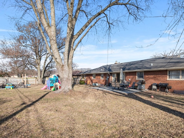 view of yard with a patio, a playground, and fence