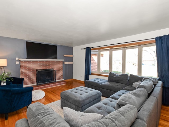 living area with a healthy amount of sunlight, wood finished floors, and a fireplace