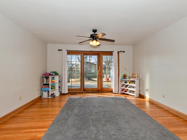 playroom with baseboards, light wood-style floors, and a ceiling fan