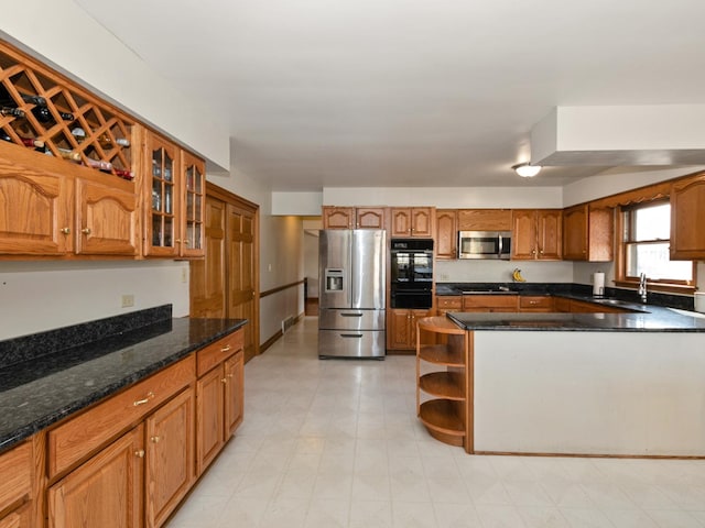 kitchen featuring a sink, glass insert cabinets, brown cabinetry, stainless steel appliances, and open shelves