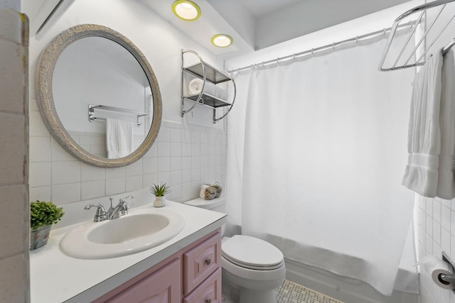 full bathroom featuring toilet, shower / bathtub combination with curtain, tile walls, and vanity