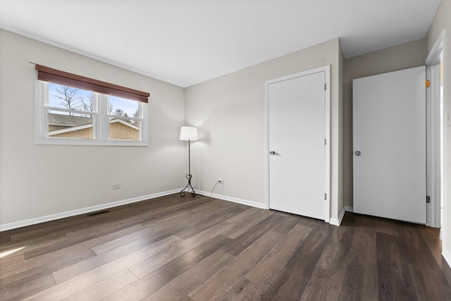 unfurnished bedroom featuring visible vents, baseboards, and wood finished floors