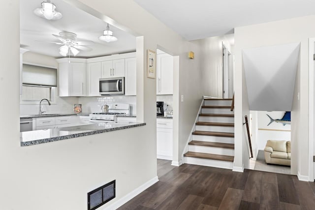 kitchen featuring dark wood-style flooring, a sink, visible vents, white cabinets, and appliances with stainless steel finishes