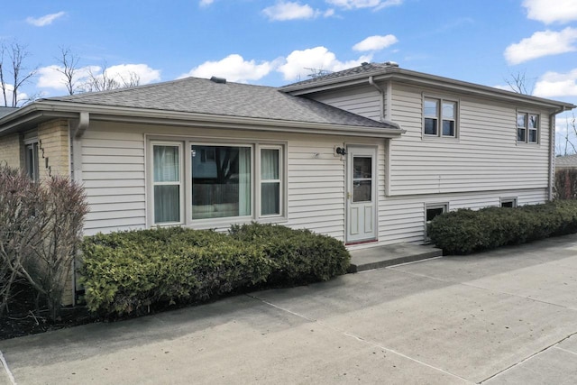 split level home featuring a shingled roof