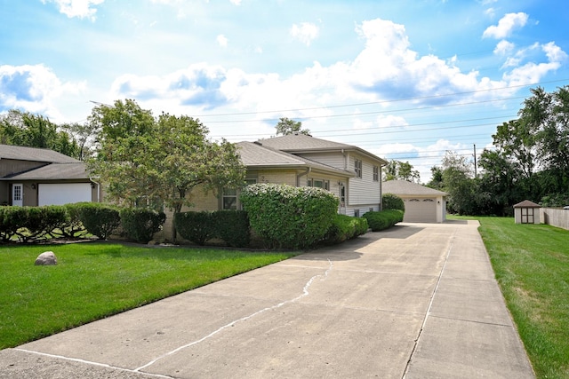 split level home featuring brick siding, a front yard, a detached garage, and an outdoor structure