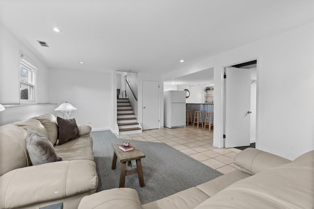 living area with light tile patterned floors, stairs, visible vents, and recessed lighting