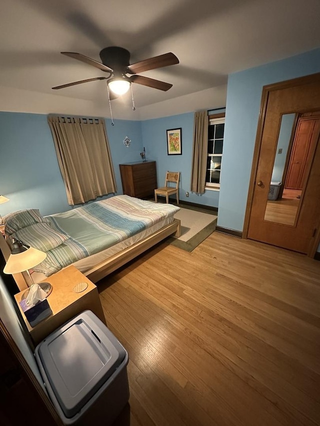 bedroom featuring a ceiling fan, baseboards, and light wood finished floors