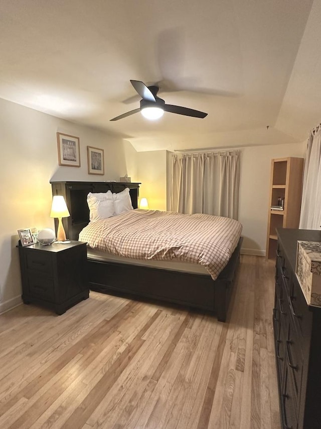 bedroom featuring light wood-type flooring, a ceiling fan, and baseboards