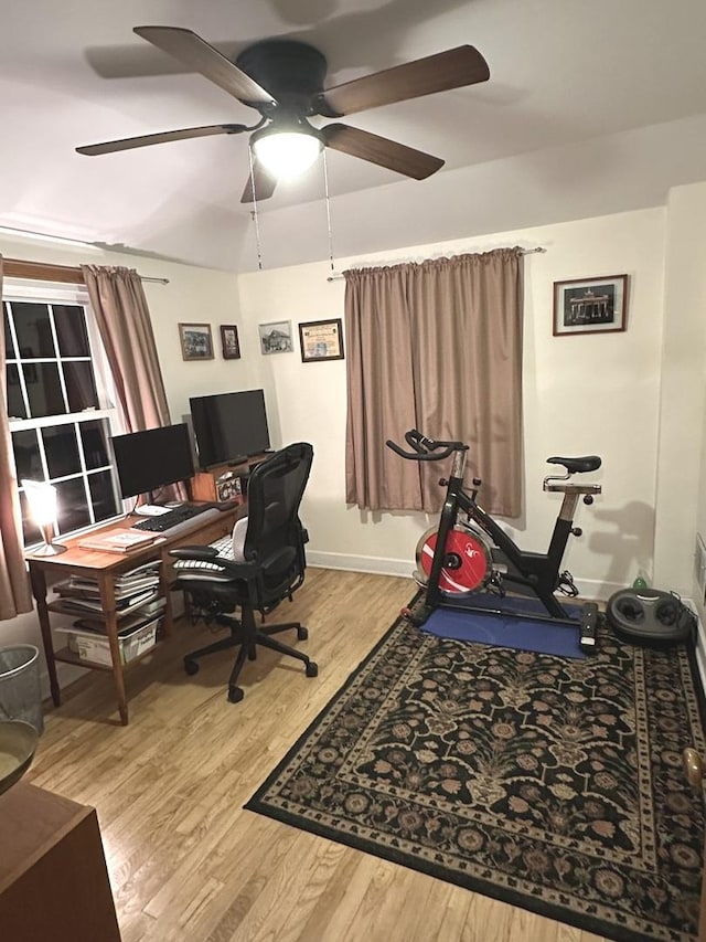 office area with light wood-type flooring, baseboards, and a ceiling fan