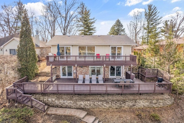 back of property with outdoor dining area, stairs, and a deck