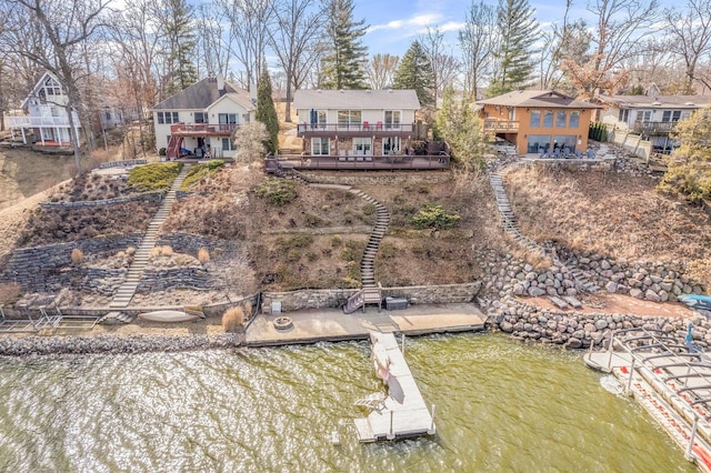 back of property featuring stairway, a residential view, and a deck with water view