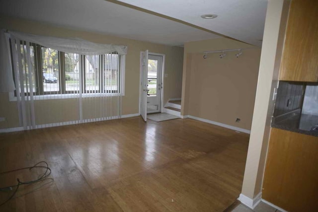 interior space with baseboards, hardwood / wood-style floors, and stairs